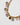 detail of the Katerina Psoma Gemma short necklace, a gold-plated chain with square crystals in grey, peach, pink, violet and brown.