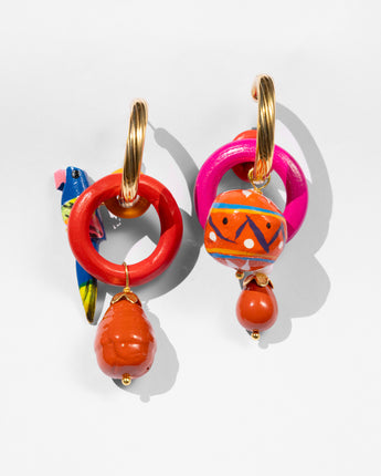 Colorful hoop earrings with orange beads on a light gray background