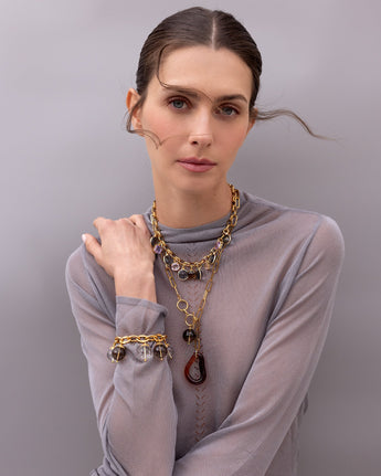 A model wearing the Katerina Psoma Luna bracelet — crystal and smoky quartz spheres on a gold-plated chain
