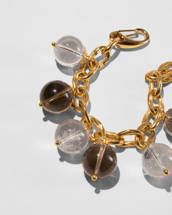 Close up photo of the Katerina Psoma Luna bracelet — crystal and smoky quartz spheres on a gold-plated chain