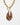 detail of  Katerina Psoma Plume necklace made of a teardrop handmade Murano glass pendant in brown, amber and red colors set on a gold plated thick metal chain with a toggle clasp. 