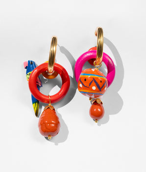 Colorful hoop earrings with orange beads on a light gray background