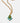 Gold necklace with a green teardrop pendant and turquoise beads on a white background
