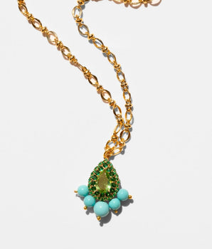 Gold necklace with a green teardrop pendant and turquoise beads on a white background