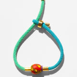Katerina Psoma Turquoise braided cord bracelet with gold accents and a red bead 