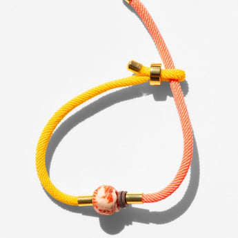 Katerina Psoma Bracelet with yellow and orange cord and a trade bead
