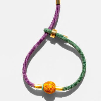 Katerina Psoma Bracelet with purple and green cord and a trade bead